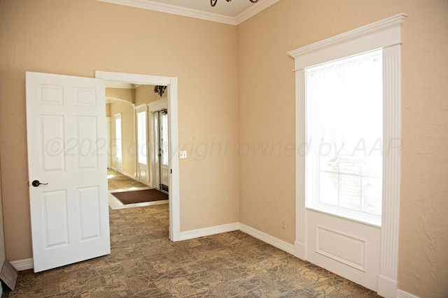 411 E 6th St, Hereford, TX 79045 - unfurnished room with healthy amount of natural light, crown molding, dark colored carpet, and baseboards