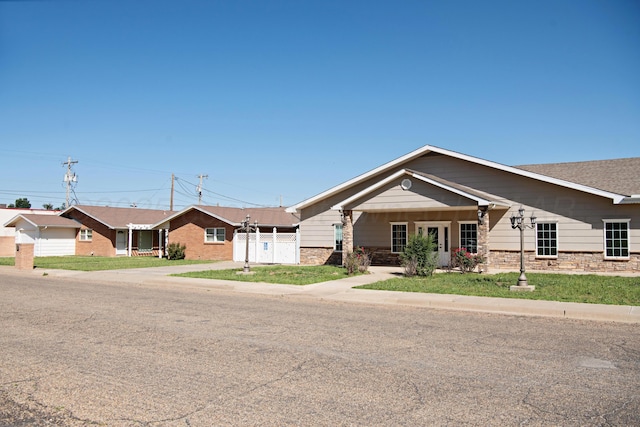 411 E 6th St, Hereford, TX 79045 - ranch-style home with driveway, an attached garage, and stone siding