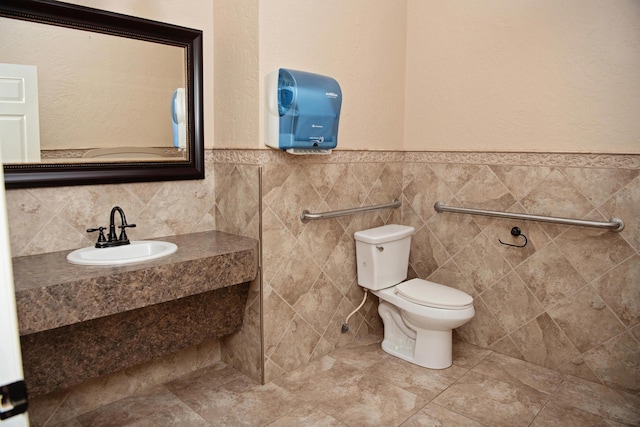 411 E 6th St, Hereford, TX 79045 - bathroom with toilet, tile walls, a wainscoted wall, and vanity