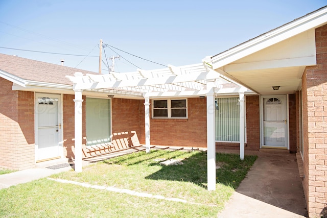411 E 6th St, Hereford, TX 79045 - entrance to property featuring brick siding, a pergola, and a lawn