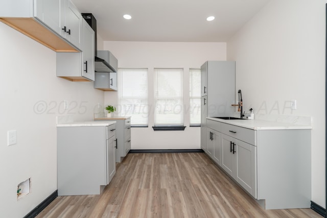 kitchen featuring recessed lighting, a sink, light wood-style flooring, and light countertops