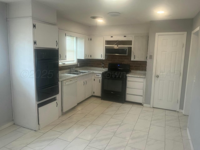 kitchen featuring light countertops, backsplash, a sink, white cabinetry, and black appliances