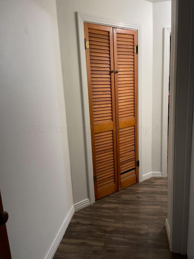 corridor featuring dark wood-style floors and baseboards