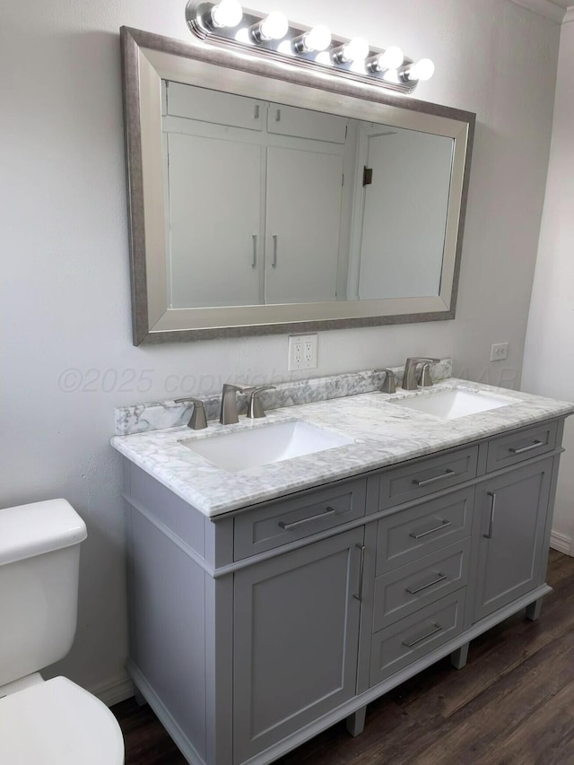 bathroom featuring toilet, wood finished floors, and a sink