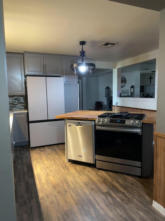 kitchen featuring butcher block countertops, gray cabinets, visible vents, stainless steel appliances, and wood finished floors