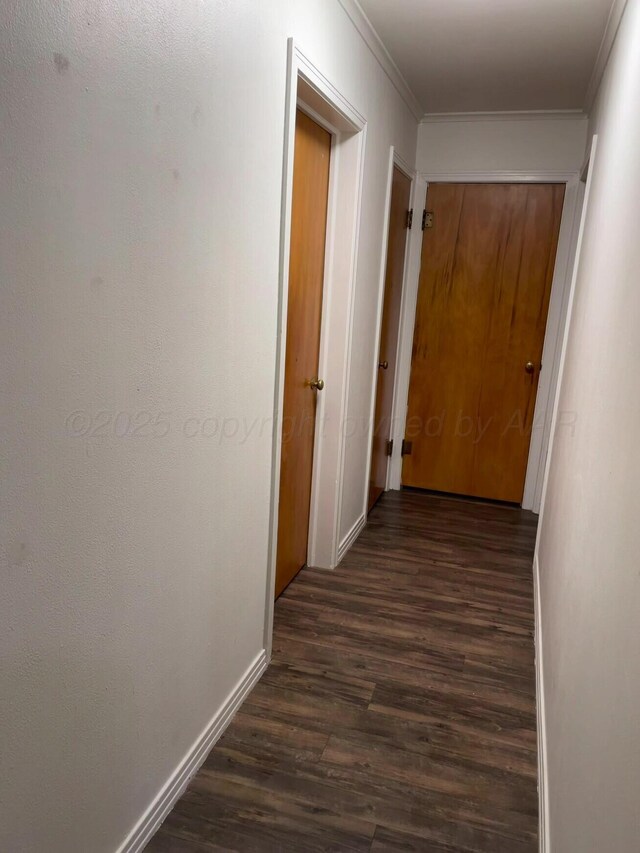 corridor with crown molding, baseboards, and dark wood-style floors