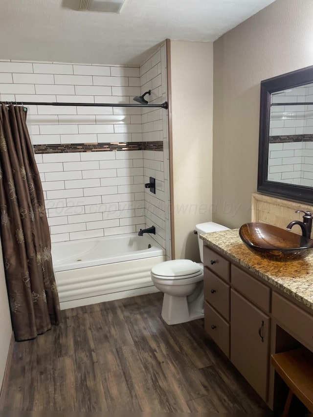 full bath with shower / tub combo with curtain, vanity, toilet, and wood finished floors