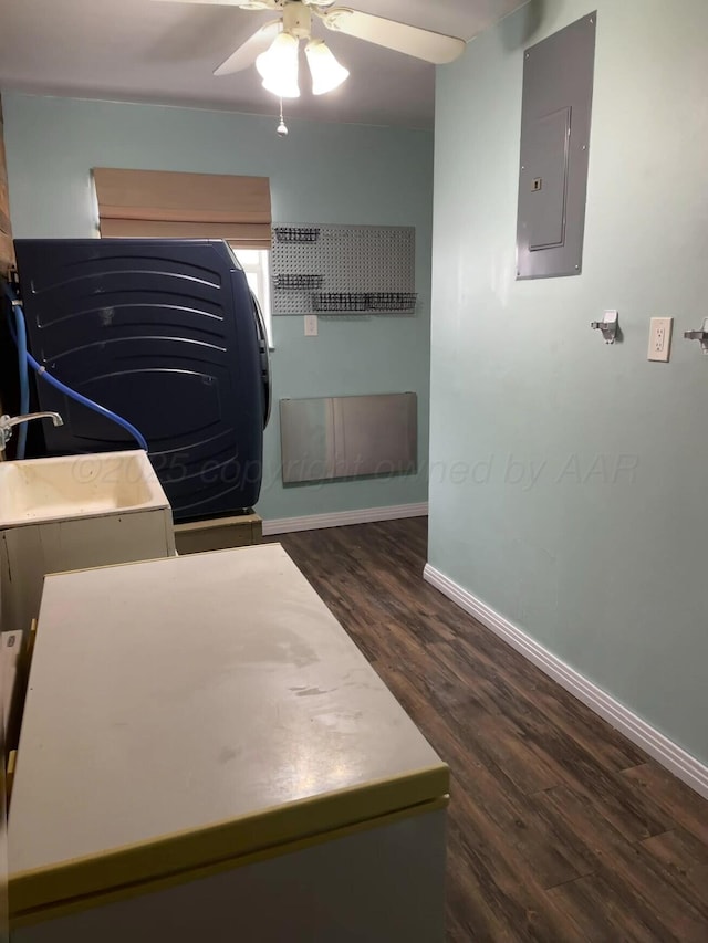 interior space featuring electric panel, baseboards, a ceiling fan, and wood finished floors
