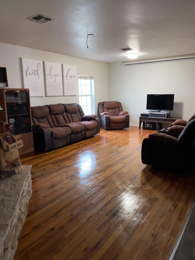 living room with visible vents and hardwood / wood-style flooring