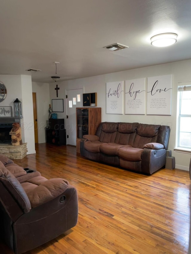 living area featuring visible vents and wood finished floors