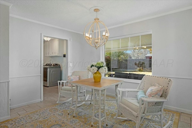 dining space with a chandelier, ornamental molding, a textured ceiling, and washer / dryer