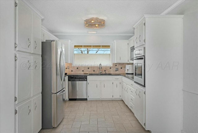 kitchen with decorative backsplash, stainless steel appliances, crown molding, sink, and white cabinetry