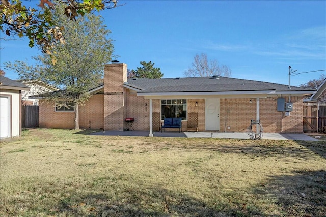 back of property with a yard and a patio