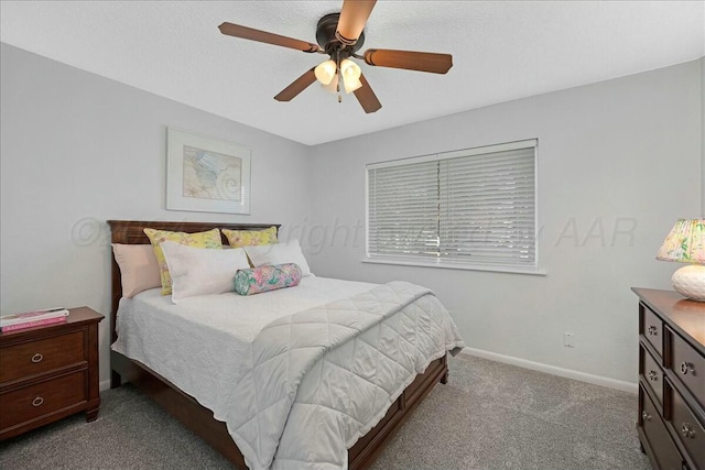 bedroom with ceiling fan, light colored carpet, and a textured ceiling