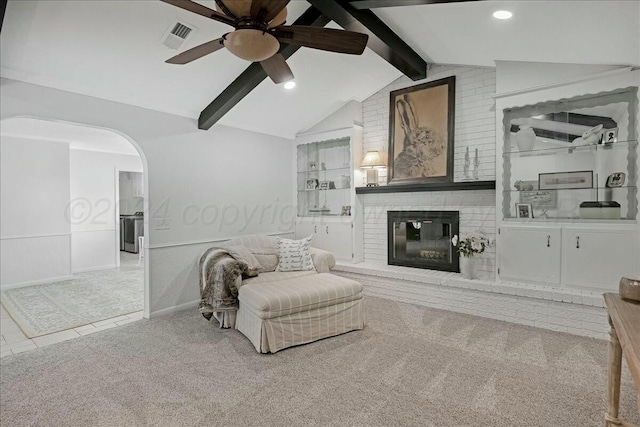 sitting room featuring carpet flooring, lofted ceiling with beams, ceiling fan, and a fireplace