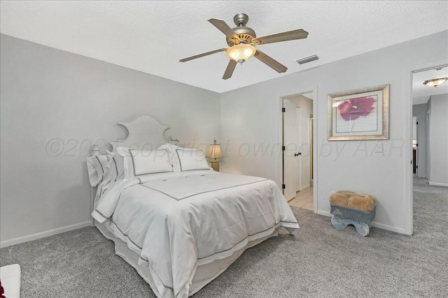 carpeted bedroom featuring a textured ceiling and ceiling fan