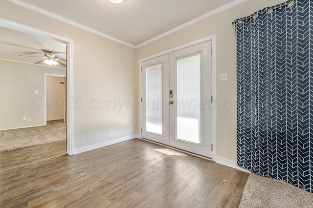 unfurnished room featuring crown molding, french doors, an accent wall, ceiling fan, and wood finished floors