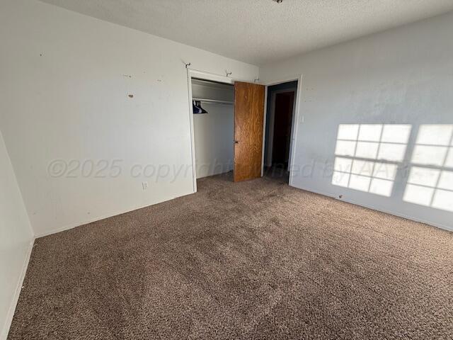 unfurnished bedroom featuring a closet, carpet floors, and a textured ceiling