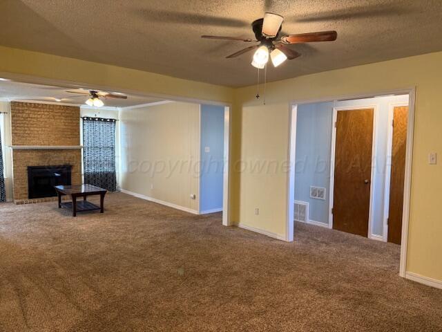 unfurnished living room with carpet flooring, a textured ceiling, and ceiling fan