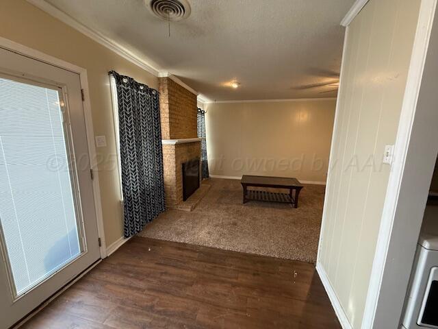 corridor featuring visible vents, crown molding, baseboards, and wood finished floors