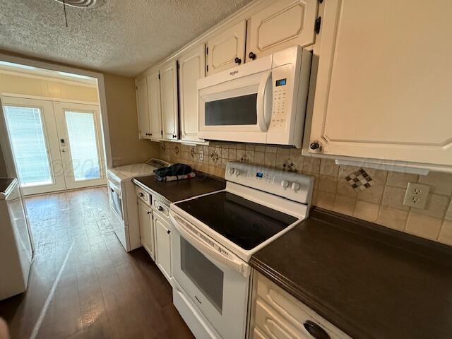 kitchen with white cabinetry, white appliances, dark wood-style floors, and backsplash