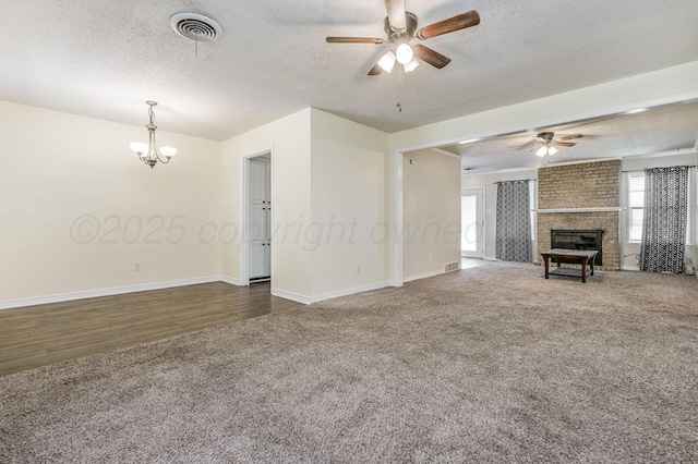 unfurnished living room with carpet, visible vents, and ceiling fan with notable chandelier