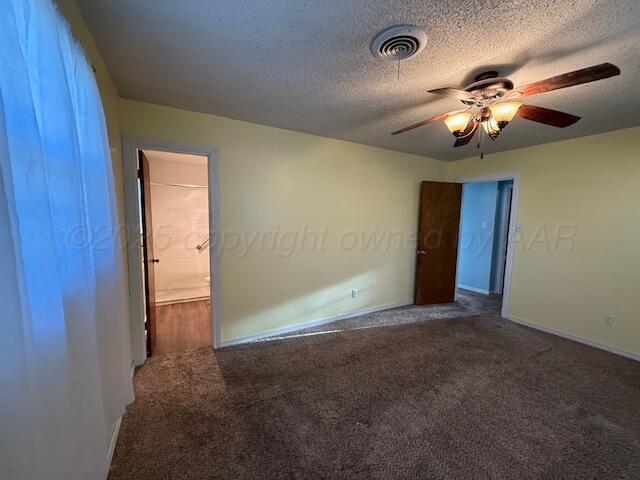 carpeted spare room featuring ceiling fan, baseboards, visible vents, and a textured ceiling