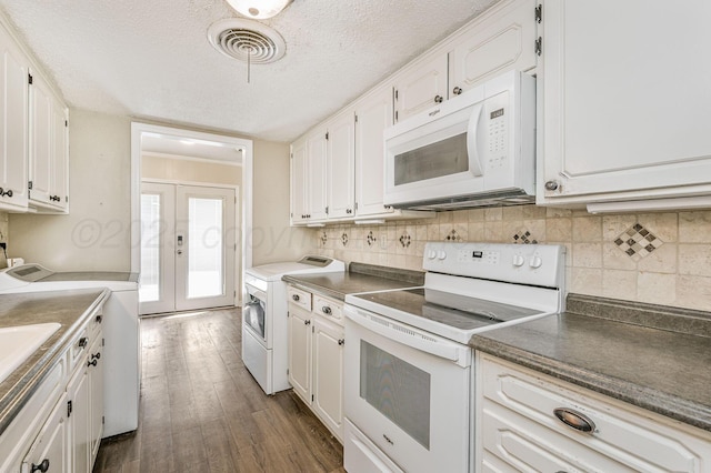 kitchen featuring white cabinetry, white appliances, dark wood finished floors, washer / clothes dryer, and visible vents