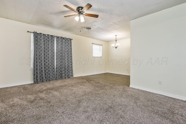 unfurnished room featuring carpet flooring, a textured ceiling, baseboards, ceiling fan with notable chandelier, and visible vents