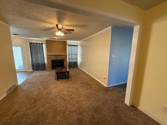 unfurnished living room with visible vents, carpet floors, ceiling fan, ornamental molding, and a textured ceiling