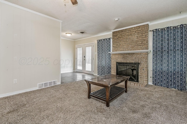 living room featuring carpet floors, a textured ceiling, visible vents, and crown molding