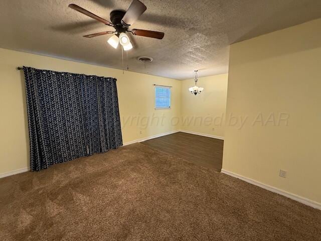 unfurnished room featuring carpet flooring, ceiling fan with notable chandelier, visible vents, and a textured ceiling