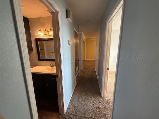 hallway featuring a sink and carpet floors