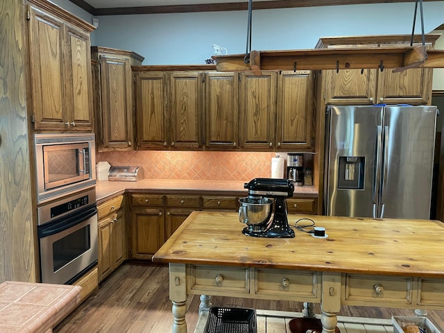 7 Pebble Beach Ct, Amarillo, TX 79124 - kitchen featuring appliances with stainless steel finishes, wooden counters, dark wood-style floors, backsplash, and crown molding
