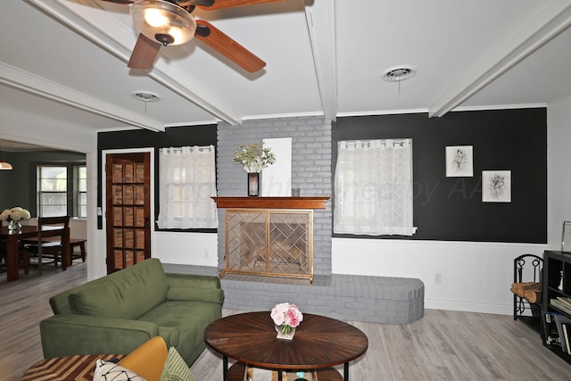 6006 Elmhurst Rd, Amarillo, TX 79106 - living area with beamed ceiling, wood finished floors, a ceiling fan, a brick fireplace, and wainscoting