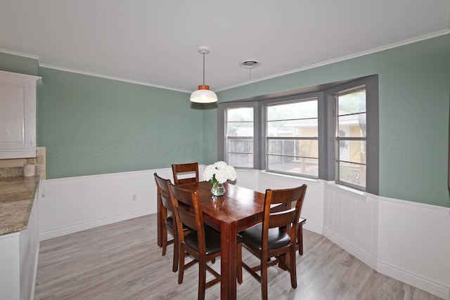 6006 Elmhurst Rd, Amarillo, TX 79106 - dining room featuring light wood-type flooring, crown molding, and wainscoting
