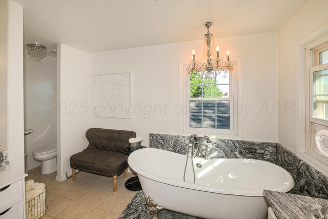 620 N Main St, Stratford, TX 79084 - bathroom with a freestanding tub, a chandelier, tile patterned flooring, and toilet