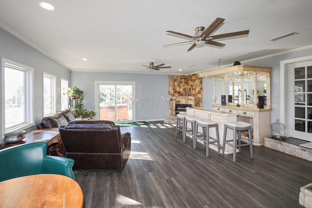 620 N Main St, Stratford, TX 79084 - living area featuring ornamental molding, a ceiling fan, dark wood-style flooring, a stone fireplace, and recessed lighting