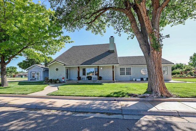 620 N Main St, Stratford, TX 79084 - view of front of home with a front yard, a chimney, and stucco siding