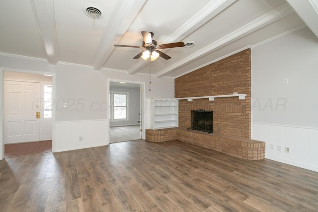 unfurnished living room with crown molding, ceiling fan, vaulted ceiling with beams, dark hardwood / wood-style floors, and a fireplace