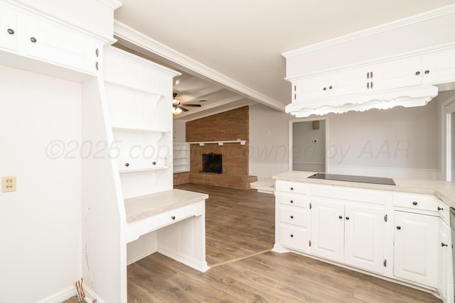 kitchen with light hardwood / wood-style flooring, ceiling fan, a fireplace, white cabinets, and black electric cooktop