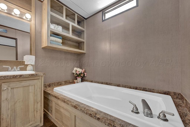 bathroom with vanity and tiled tub