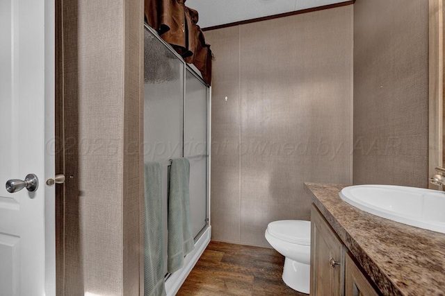 bathroom with vanity, hardwood / wood-style floors, an enclosed shower, and toilet