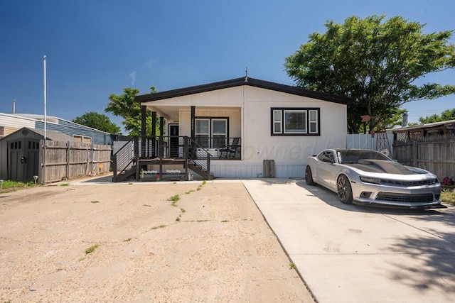 2004 Pheasant Ln, Amarillo, TX 79118 - manufactured / mobile home featuring covered porch, stairs, and a storage unit