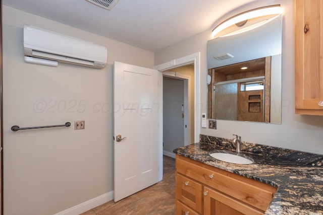 8801 Sharman Loop, Amarillo, TX 79124 - bathroom featuring a wall unit AC, visible vents, baseboards, vanity, and a shower with door