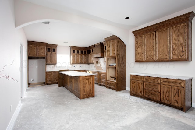 kitchen featuring light brown cabinets and custom range hood