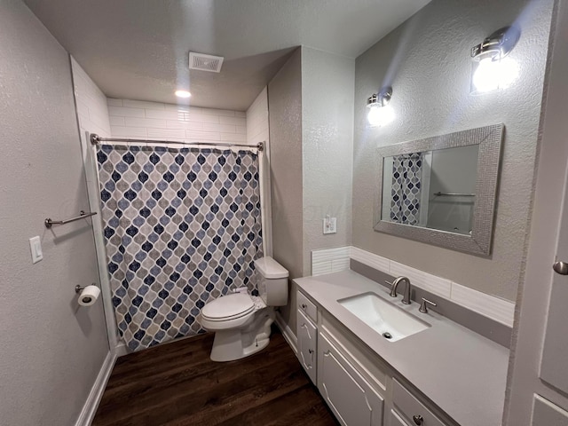 224 Beach St, Hereford, TX 79045 - full bathroom featuring vanity, toilet, curtained shower, wood finished floors, and visible vents