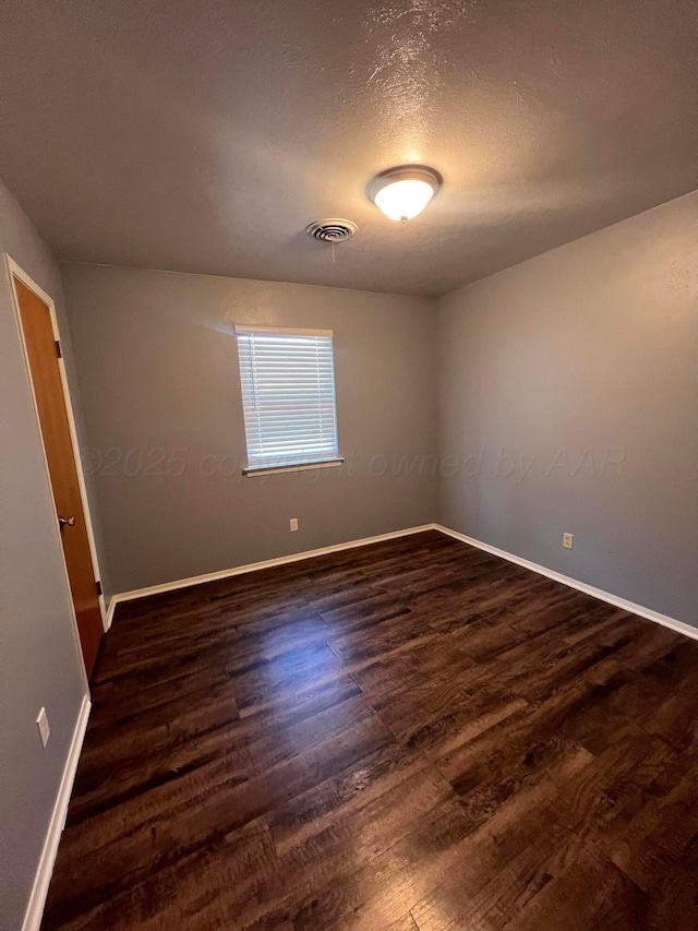 224 Beach St, Hereford, TX 79045 - unfurnished room featuring baseboards, dark wood-style floors, and visible vents