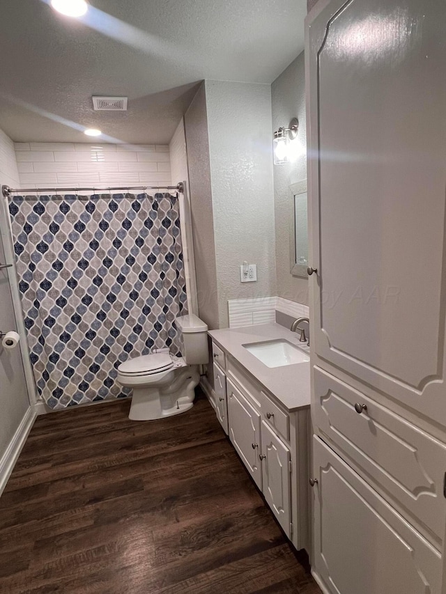 224 Beach St, Hereford, TX 79045 - bathroom with a shower with curtain, visible vents, wood finished floors, vanity, and toilet