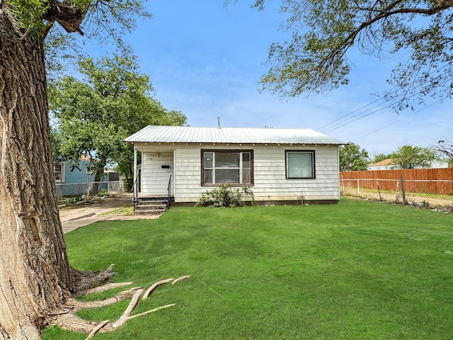 2709 NE 20th Ave, Amarillo, TX 79107 - back of property featuring fence, a yard, and metal roof